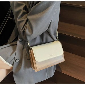 Detail shot of vintage leather crossbody bag with beige flap and gold chain strap