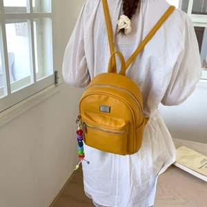 Mini sac à dos jaune vif en cuir grainé avec pendentif en perles arc-en-ciel colorées
