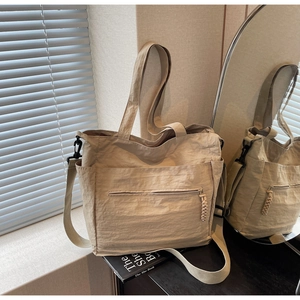Detail view of khaki nylon tote bag with pleated texture and adjustable shoulder strap