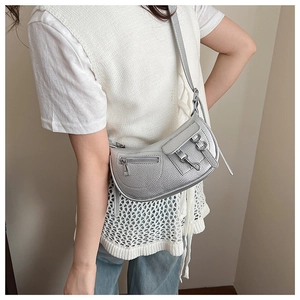 Close-up of a silver Y2K hobo bag with litchi texture and stylish metal buckles on a model