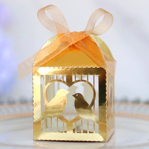 Détail boîte à bonbons dorée découpée au laser avec motif cœur et ruban orange