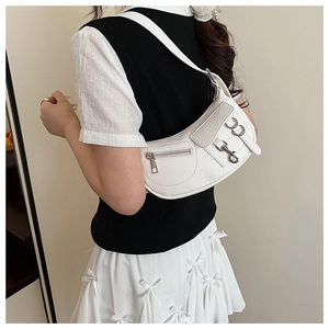 Detail of white pebbled leather crescent bag with biker-style zippers and metal buckle