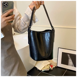 Detail view of black crocodile pattern bucket bag with FASHION & BAGS logo branding