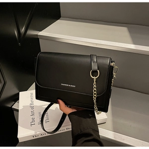 Detail of a black leather crossbody bag with chain strap and Fashion & Bags text logo