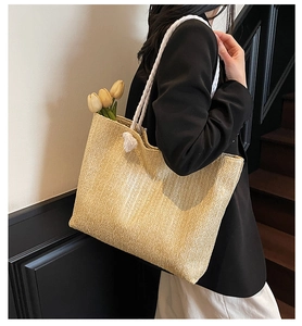 Detail of straw tote bag with thick woven rope handles and inner floral decoration