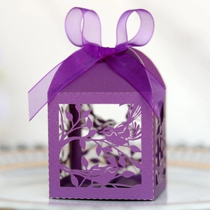 Detail of laser-cut purple candy box featuring bird patterns and a silk ribbon bow