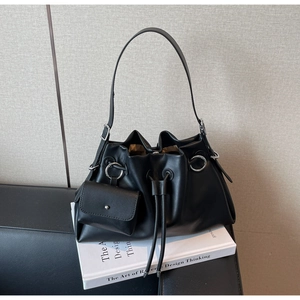Detail of black faux leather drawstring bucket bag with a detachable mini square pouch