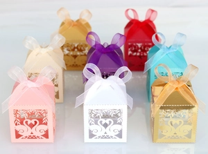 Detailed laser-cut swan candy boxes with silk ribbons in multiple colors for weddings