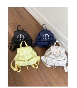 Detailed view of casual backpacks in four colors with vintage D print and metal rivets