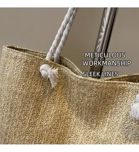 Detail of woven straw tote bag featuring herringbone texture and white cotton rope handles