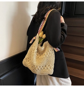 Detail of hand-woven beige hobo bag with vibrant colorful ethnic style shoulder strap