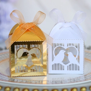 Boîte à bonbons découpée au laser avec nœud en organza sur une assiette décorative