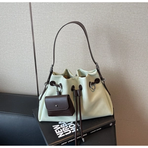 Detail of cream and brown leather drawstring bucket bag with mini purse and metal rings