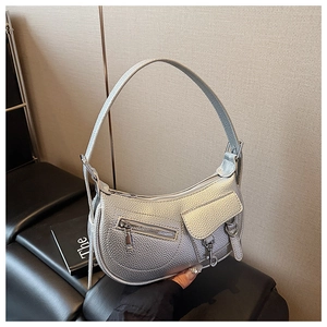 Detail of silver half-moon bag featuring lychee texture and multi-pocket design