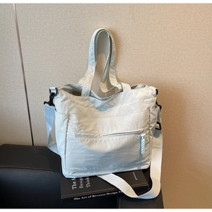 Detail view of large nylon tote bag with zipper pockets and adjustable shoulder strap