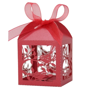 Detail of red laser-cut candy box with lovebirds floral pattern and chiffon ribbon bow