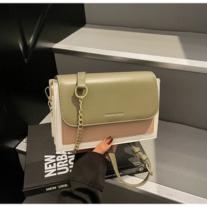 Detailed shot of tri-color shoulder bag with gold chain and elegant branding