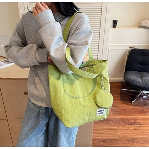 Detail of waterproof nylon tote bag with mini coin purse attachment and woven brand label