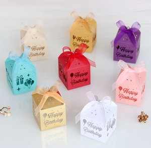 Macro detail of laser-cut Happy Birthday candy boxes in multiple colors with satin ribbons