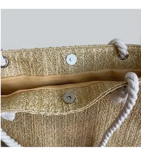 Detail of the woven straw tote bag featuring a strong magnetic closure and hemp rope handle