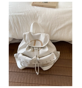Detail of white backpack with flap drawstring closure and artistic D letter print on front