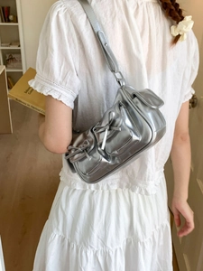 Sac à épaule argenté métallisé avec nœud et poches multiples porté par un mannequin