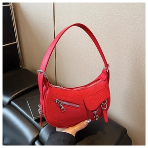 Detail of red lychee textured leather crescent bag with silver zippers and hardware