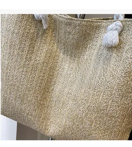 Detail of hand-woven straw tote bag texture with white cotton rope handle