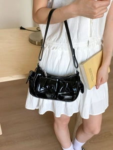 Sac à bandoulière en cuir verni noir brillant avec nœud et poches utilitaires