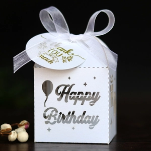Detail of laser-cut Happy Birthday candy box with ribbon and gold foil thank you tag
