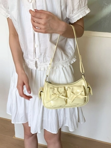 Sac sous le bras jaune crème à la mode avec nœuds décoratifs et poches latérales sur modèle