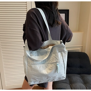 Back view of a light blue large capacity tote bag with functional multi-pockets for commuting