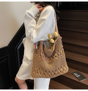 Detailed close-up of handmade straw tote bag with a colorful bohemian shoulder strap