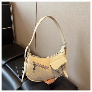 Detail of lychee pattern leather and silver hardware on a cream crescent bag