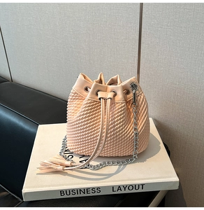 Detail of pink bucket bag featuring wave pattern texture and stylish tassel decoration