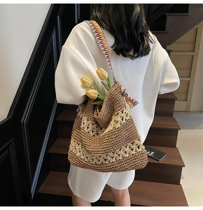 Detailed shot of woven tote bag with colorful ethnic embroidery strap and hollow patterns