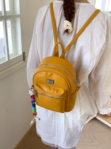 Sac à dos minimaliste jaune moutarde en cuir avec fermeture éclair et charm coloré