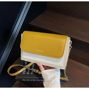 Detail of color-block crossbody bag with FASHION & BAGS print and gold chain strap
