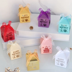 Close-up of laser-cut Happy Birthday candy boxes with elegant ribbons and hollow patterns