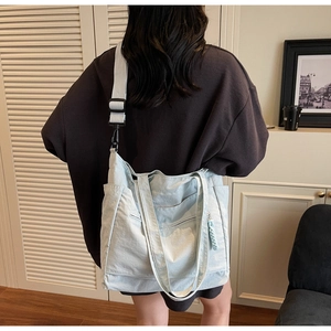 Detail view of the spacious light blue nylon tote bag with adjustable shoulder strap