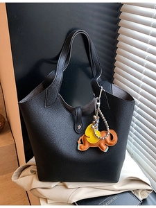 Minimalist black pebbled leather tote bag featuring a cute elephant charm and bucket style design
