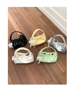 Detail of colorful ruched cloud bags with pearl heart charms and lace bow accessories