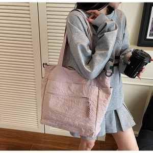 Detail view of a lavender large tote bag featuring side pockets and front zipper pocket