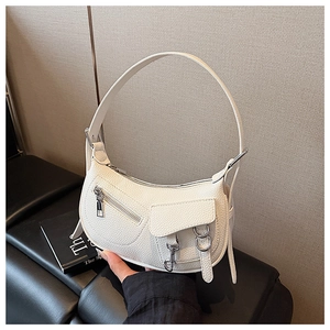 Detailed view of white lychee leather texture and silver buckle on the saddle shoulder bag