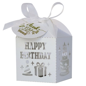 Close-up of white laser-cut Happy Birthday candy box with ribbon and thank you tag