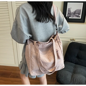 Detailed side view of a large dusty pink tote bag worn on shoulder in minimalist interior