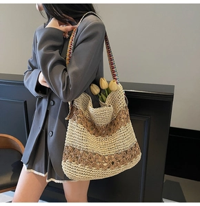Detail of hand-woven straw tote bag with cutout patterns and colorful bohemian strap