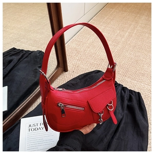 Detail of red lychee textured leather biker-style shoulder bag with silver hardware