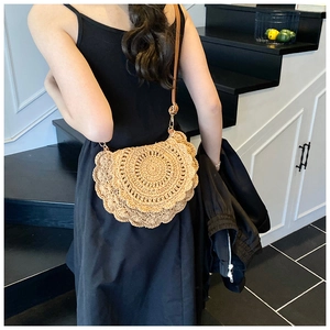 Detail of bohemian woven saddle bag with scalloped edges and slim leather shoulder strap