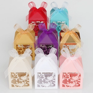 Laser cut favor boxes with bird motifs and ribbons in various colors for weddings